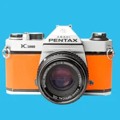 Pentax K1000 Orange Leather Vintage SLR 35mm Film Camera with Pentax f/2 50mm Prime Lens.